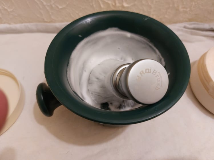 proraso shaving mug with lather and yaqi shaving brush inside