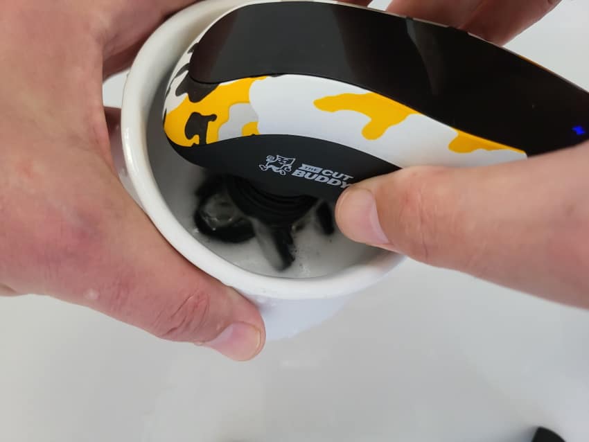 cleaning the Bald Buddy shaver with soap inside a bowl