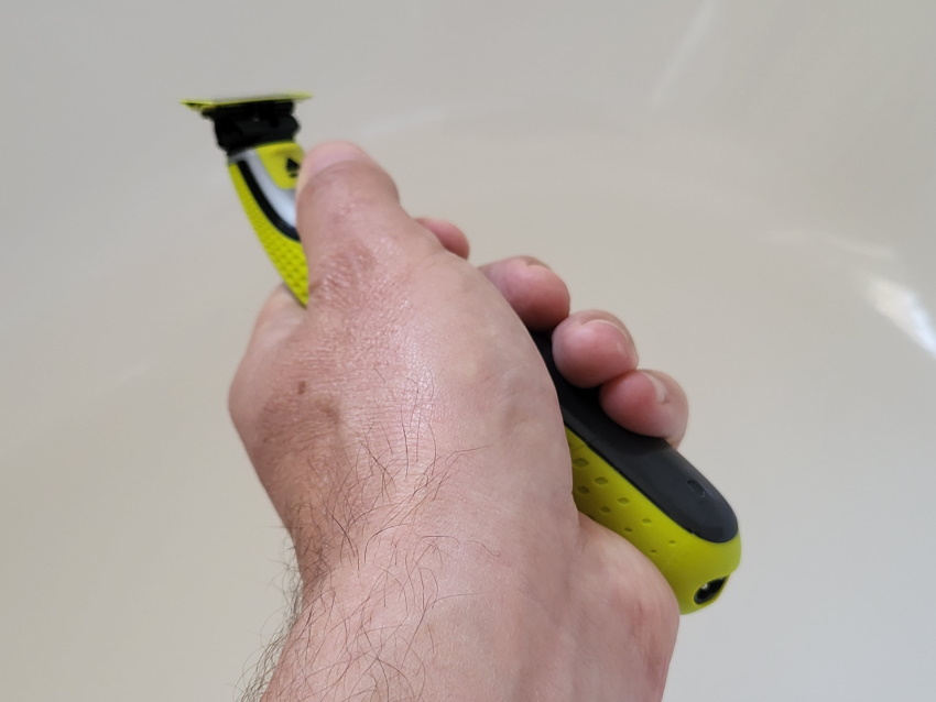 holding the Philips OneBlade to display its appearance