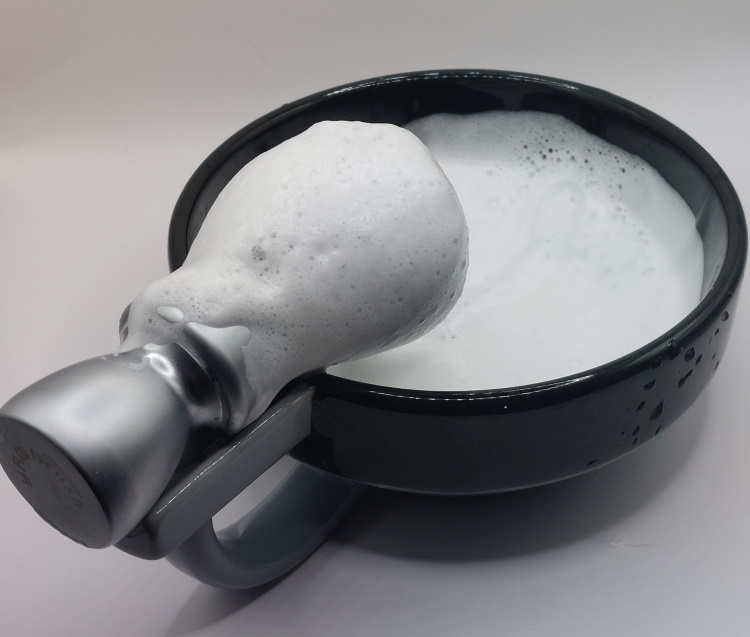 Cella Milano Aloe Vera shaving cream soap lathered inside the shaving bowl with a brush
