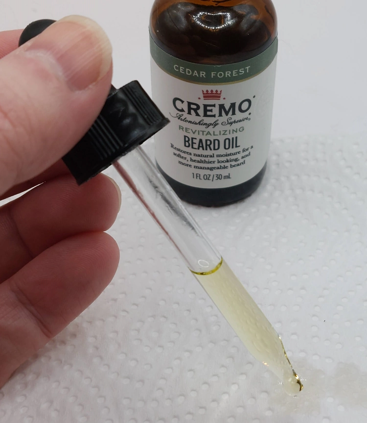 close up of using the Cremo Cedar Forest Beard Oil dropper