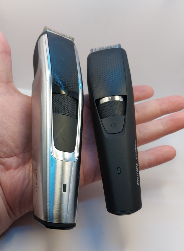Philips Norelco Series 3000 beard trimmer and 5000 series trimmer held together on the hand