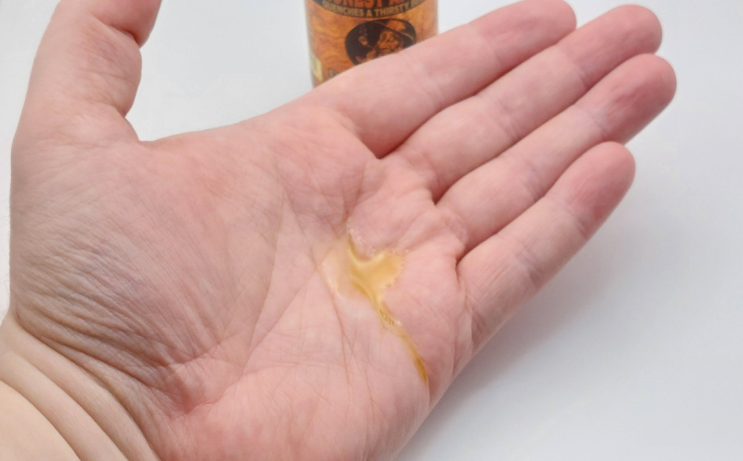 a couple of drops of Honest Amish Premium Beard Oil on the hand to show how much to apply