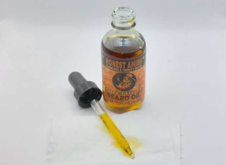 bottle of Honest Amish Premium Beard Oil opened with dropper at the side