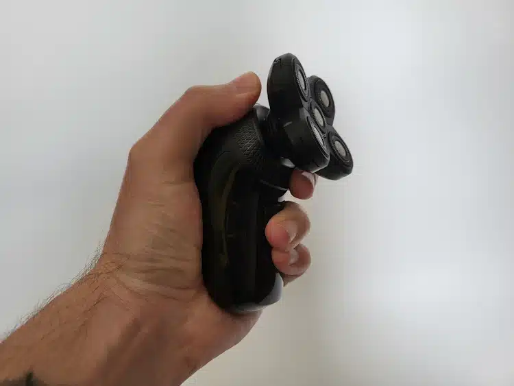 holding the Groomie BaldiePro Head Shaver to show it is ergonomically friendly
