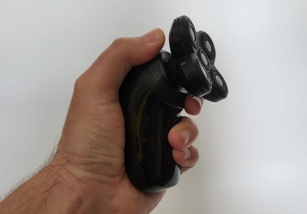 holding the Groomie BaldiePro Head Shaver to show that it is ergonomically friendly