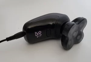 the Groomie BaldiePro Head Shaver plugged in charging