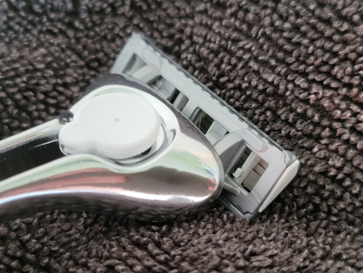 close up of patting the Schick Quattro Titanium Razor on a towel to help it dry quickly