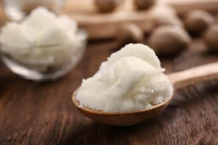 shea butter prepared on a spoon on wooden table