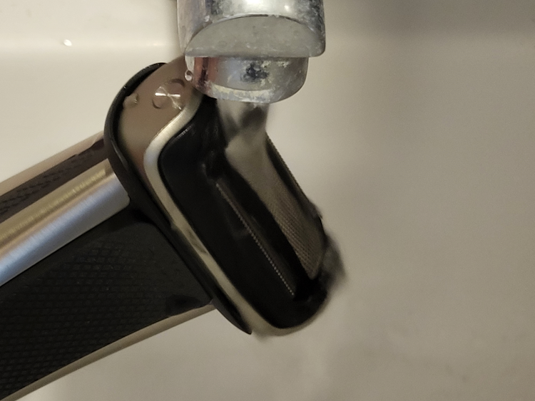 running tap water over the Philips Norelco Bodygroom 7000 Series to clean it