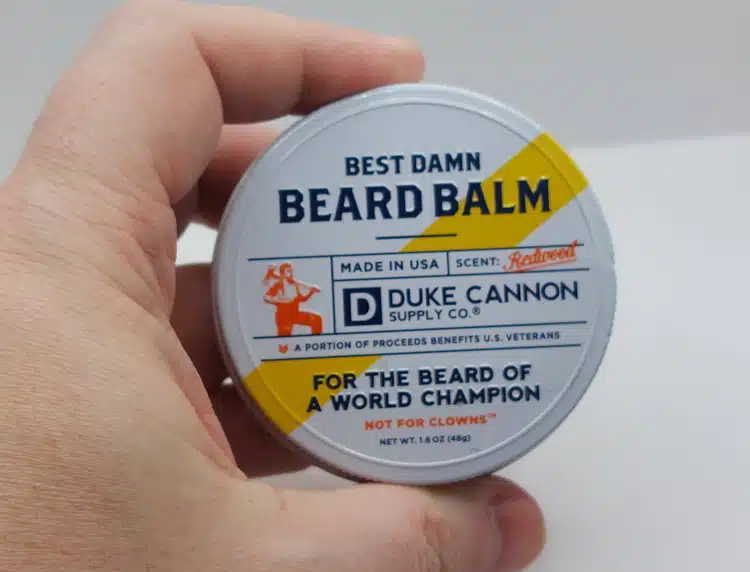 Best Damn Beard Balm held in hand ready to open