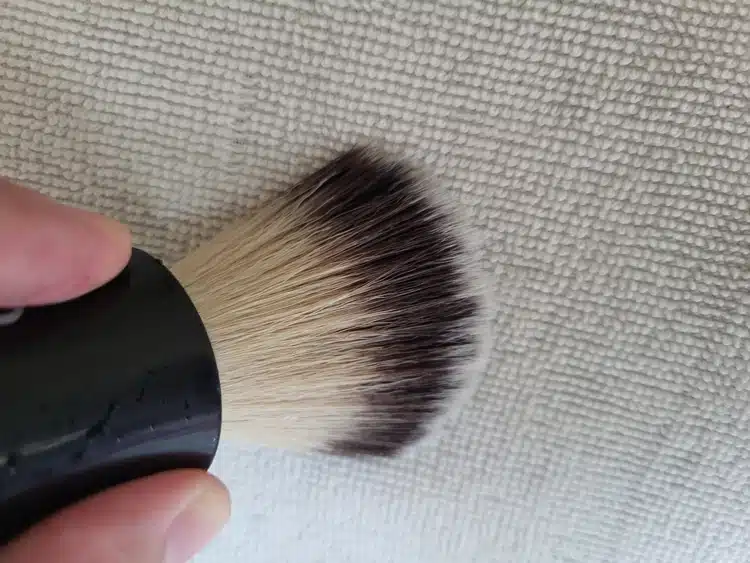 gently drying a shaving brush on a towel