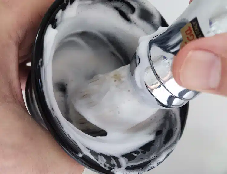 lathering shaving soap in a shaving bowl with brush