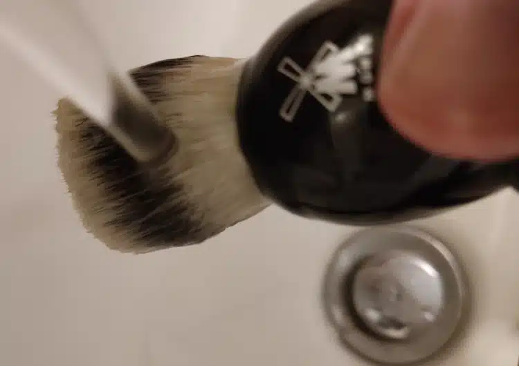 rinsing a shaving brush under the tap