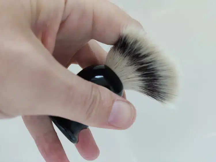 testing the backbone of a shaving brush to see how strong it is