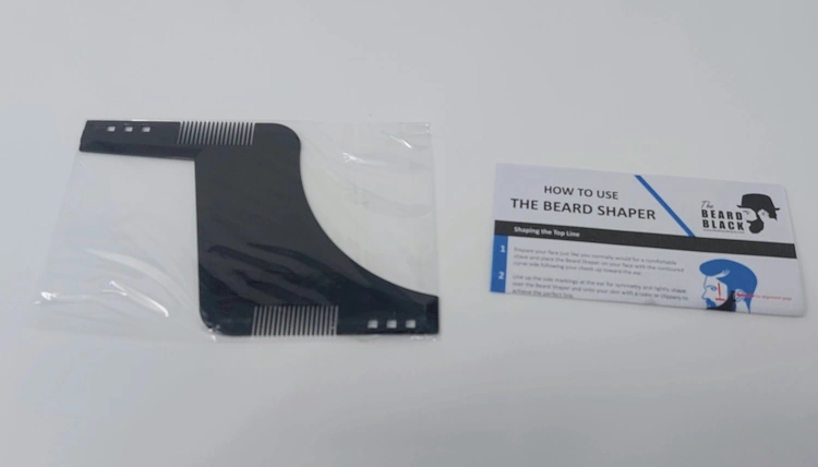 The BEARD BLACK Beard Shaping Tool in its wrapper and with the instructions next to it