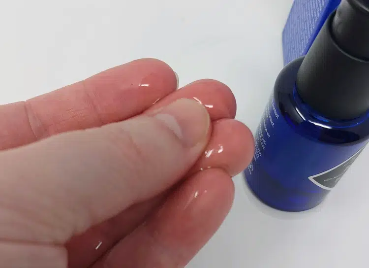 rubbing Jack Black Beard Oil between the fingers to display its texture