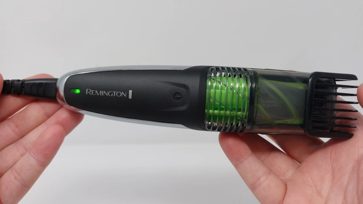 Remington Vacuum Beard and Stubble Trimmer 6000 charging showing its green light held in the hand