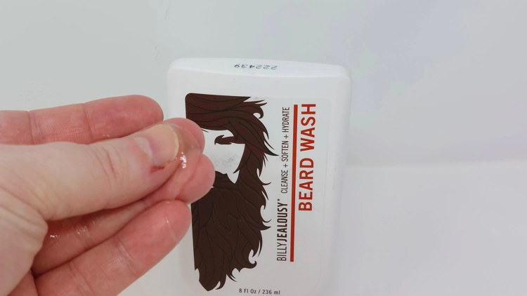 rubbing a portion of Billy Jealousy Beard Wash between the fingers to show its texture