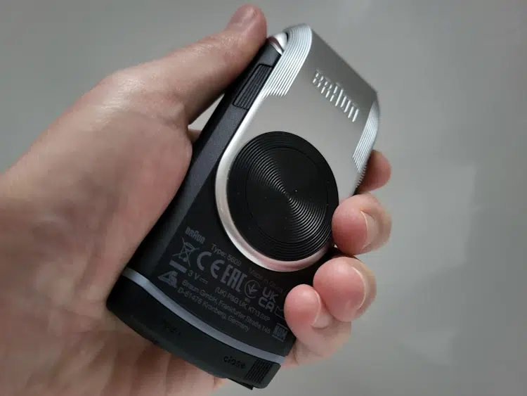 holding the Braun MobileShave M-90 shaver to display its grip and ergonomics