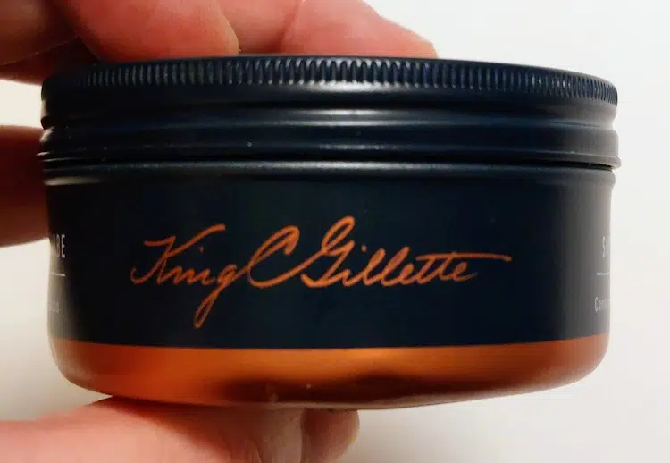 a close up holding the King C Gillette Soft Beard Balm tub showing the writing