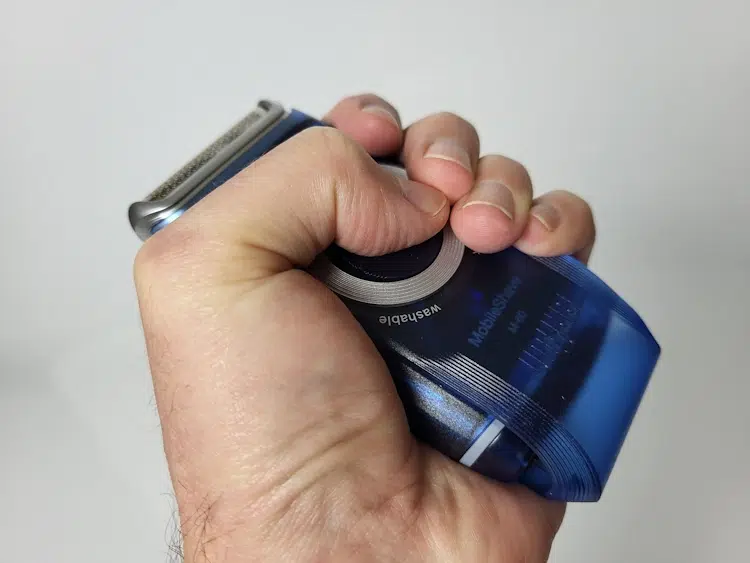 holding the Braun MobilShave M-60 to show its lack of ergonomics