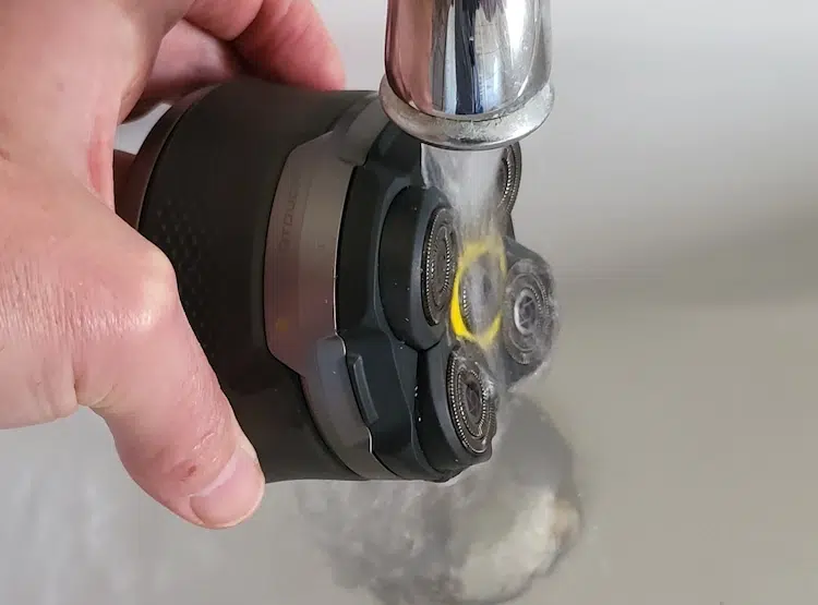 cleaning the Microtouch Titanium Head Shaver under the tap with water running