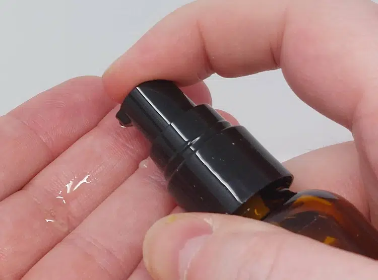 close up of beard oil bottle pump applicator being used