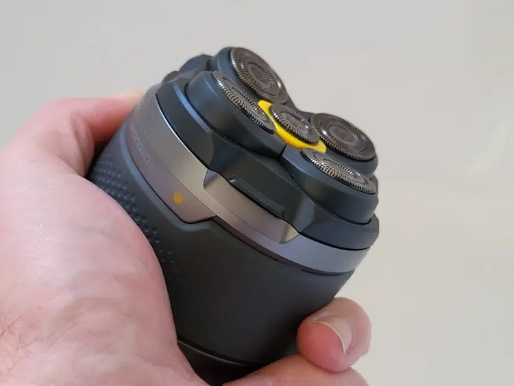 holding the Microtouch Titanium Head Shaver to display its ergonomics
