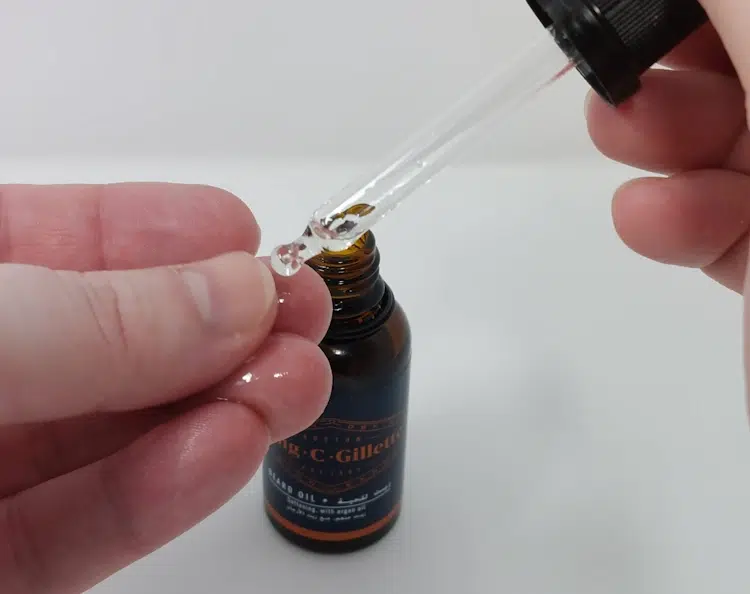 putting a drop of beard oil on the hand ready to use
