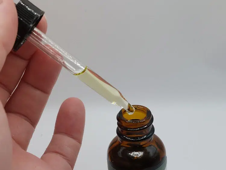 taking oil with a dropper from a beard oil bottle