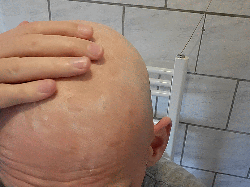 applying Headblade HeadLube matte lotion on bald head