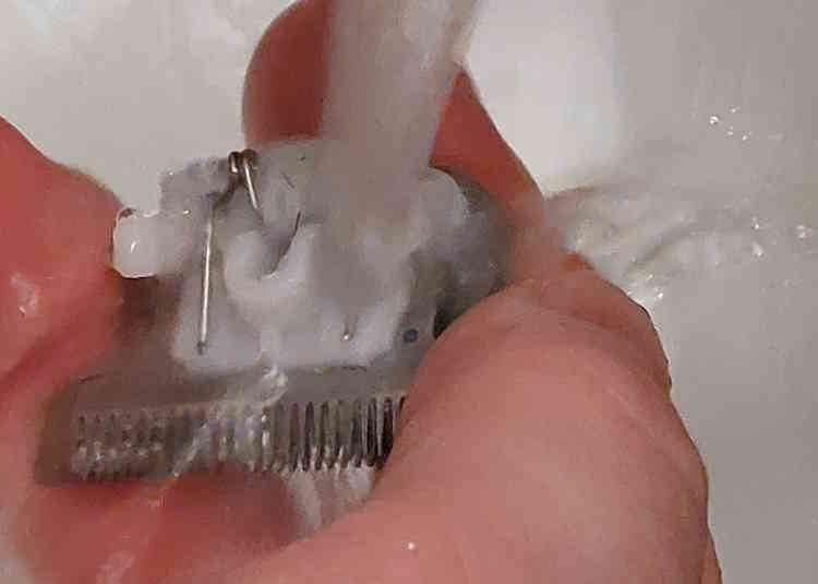cleaning the Wahl Stainless Steel Lithium-Ion 2.0 Beard Trimmer blade under tap water