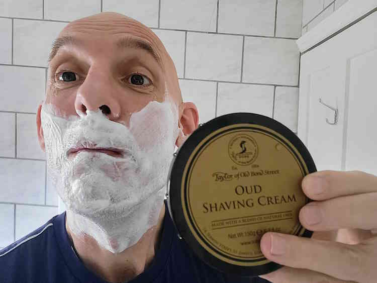 reviewer Jason holding a tub of TOBS Oud Shaving Cream with face lathered