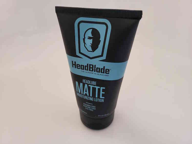 tube of Headblade HeadLube matte lotion standing up on its top