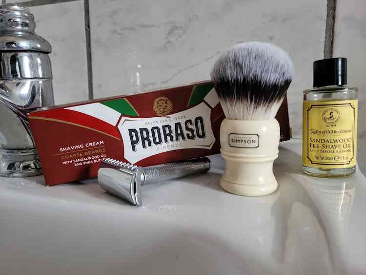 Simpson Trafalgar T3 Sovereign Synthetic Shaving Brush with razor, proraso shaving cream, and razor on bathroom sink