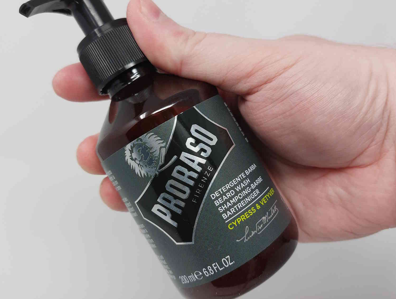 a bottle of Proraso Beard Wash held at an angle