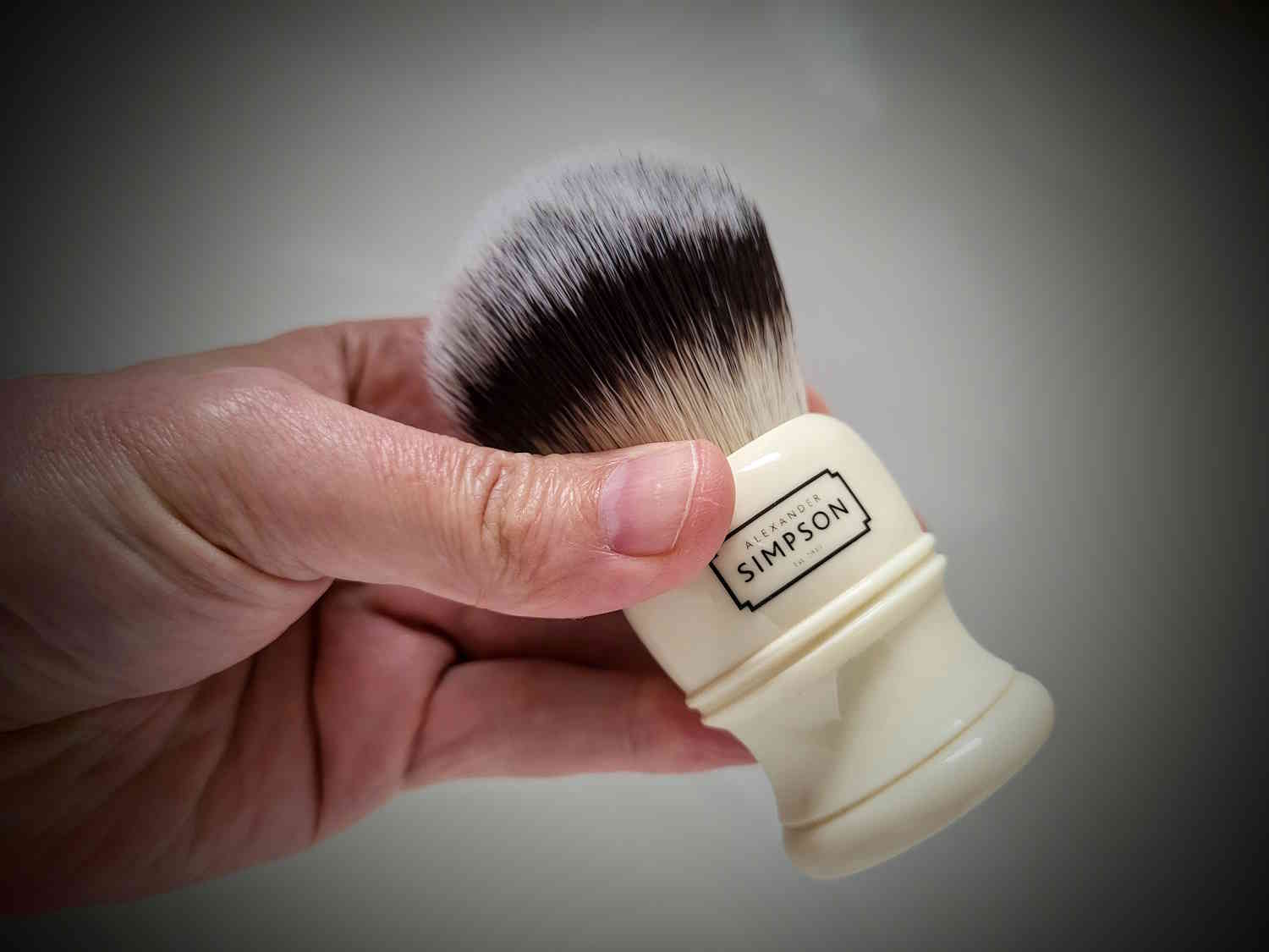 holding a Simpson Trafalgar T3 Synthetic Shaving Brush