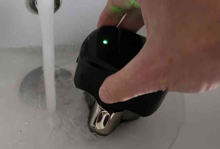 putting Skull Shaver Palm in water to clean the blades after use