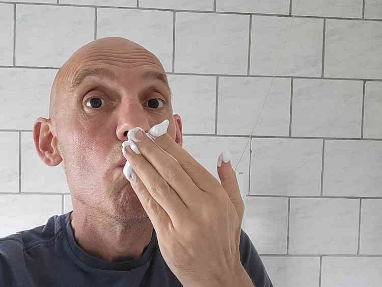 reviewer Jason smelling Proraso shaving foam to test scent