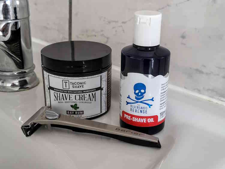 Bluebeards Revenge Pre-Shave Oil with Taconic Bay Rum shaving cream and razor on the sink