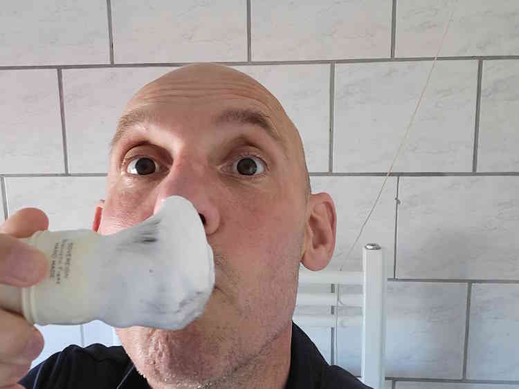 Reviewer Jason smelling Taconic Bay Rum Shaving Cream from a loaded Simpson shaving brush