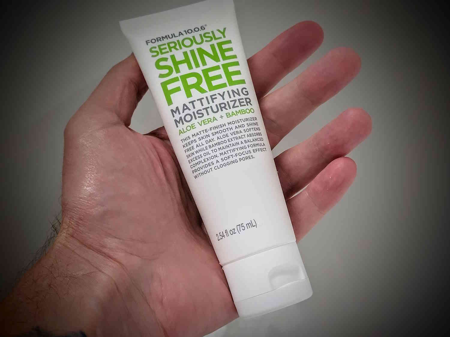 holding a tube of Formula 10.0.6 Seriously Shine Free Mattifying Moisturizer