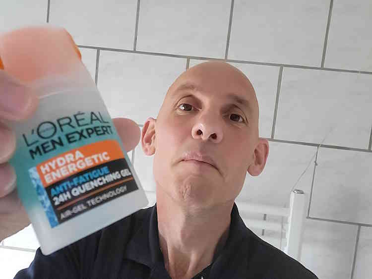 reviewer Jason holdinga bottle of Men Expert Hydra Energetic Anti-Shine Moisturizer