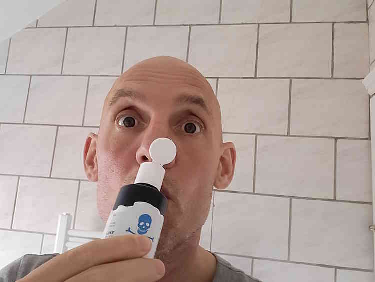 reviewer Jason smelling from the bottle of Bluebeards Revenge Pre-Shave Oil bottle