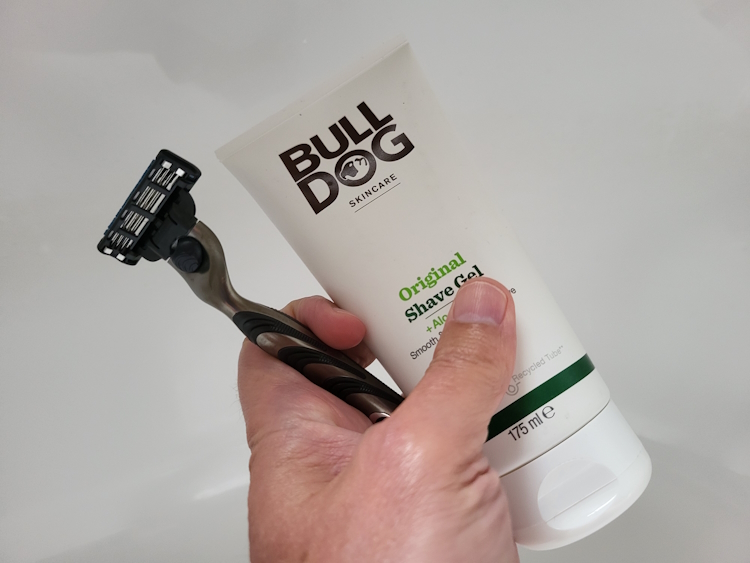 holding a tube of Bulldog Original Shave Gel and Gillette Mach3 razor