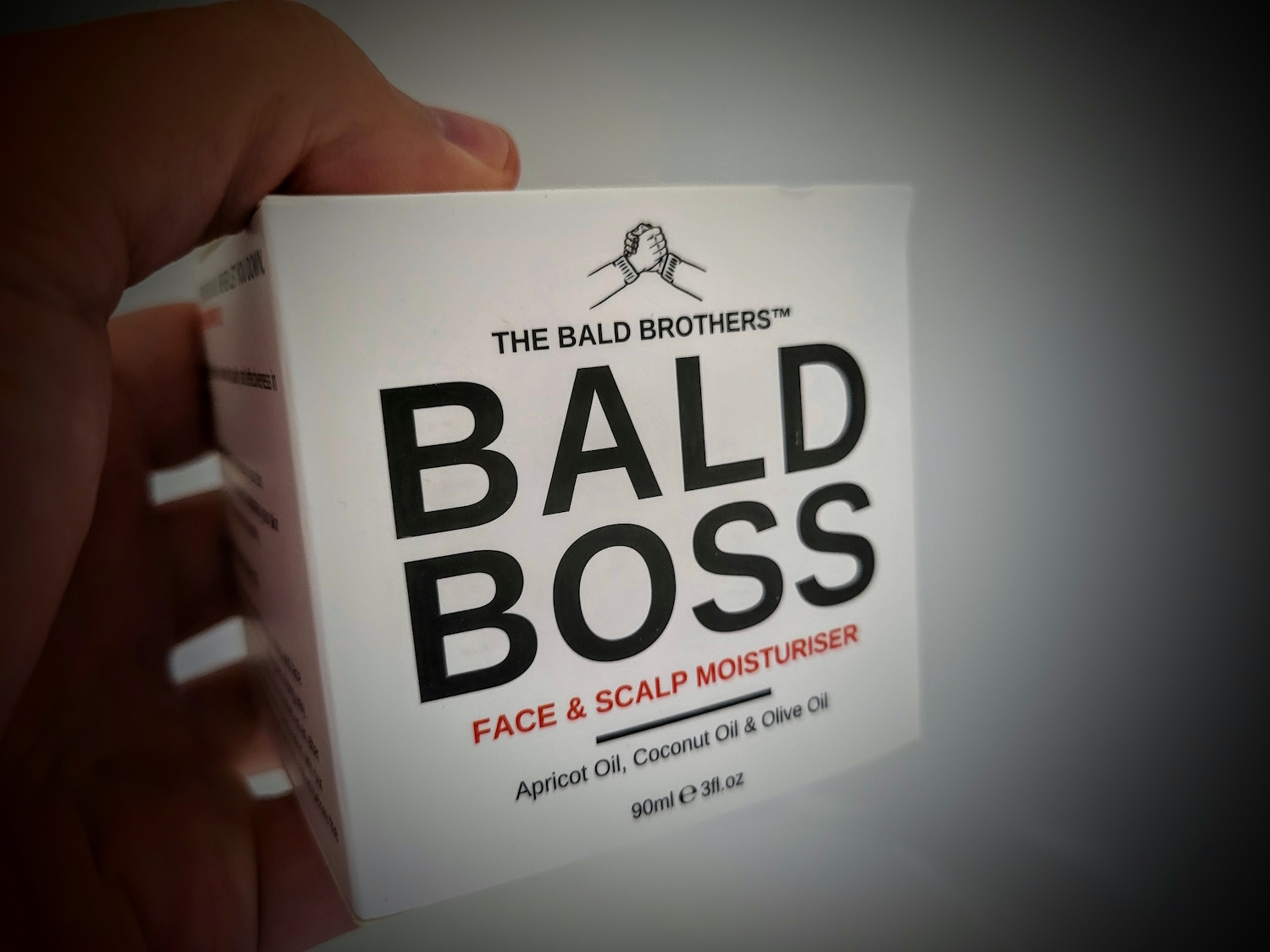 holding Bald Boss Face & Scalp Moisturiser in box