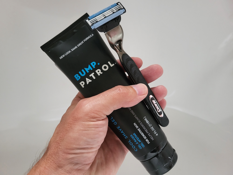 holding a tube of Bump Patrol shave gel and Gillette Mach3 razor