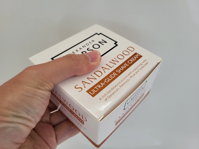 holding Simpson Sandalwood Shaving Cream in its unopened box