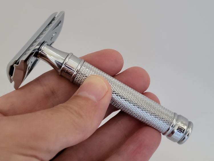 holding an Edwin Jagger DE89 razor between fingers and a thumb